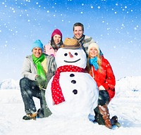 Group of friends posing with a snowman.