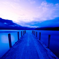 Boat jetty and a calm lake at sunrise, New Zealand.