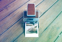 Vintage retro instant photo camera on the wooden table