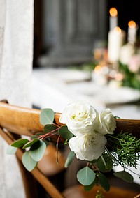 White Roses Wrapped on Wooden Chair Decorate on Wedding Reception