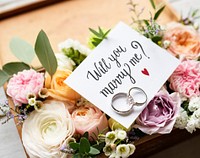 A Surprise Marriage Proposal with Will You Marry Me Card and Rings on Flowers Bouquet Present Love