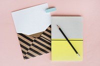 Stripe Envelope with Paper and Notebook on Pink Background