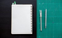 Open notebook with cutting board stationery on dark gray table