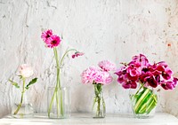 A row of vases with pink flowers