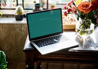 Laptop on workspace with flower decoration