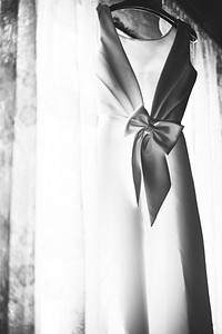 Closeup of White Wedding Dress Hanging by the Window Grayscale