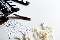 Closeup of movie tickets with popcorn and reels decoration on white table