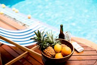 Closeup of tropical fruits in wooden basket by the poolside