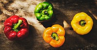 Aerial view of various bell peppers on wooden background