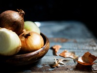 Closeup of fresh onions in wooden bowl