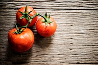 Closeup of fresh organic tomatoes on wooden background