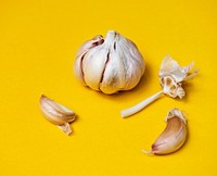 Garlic cloves on yellow background