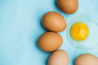 Flatlay of group of organic eggs on blue background