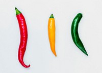 Aerial view of fresh red green yellow chili peppers on white background
