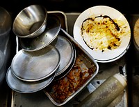 Closeup of used dishes and trays in restaurant kitchen sink