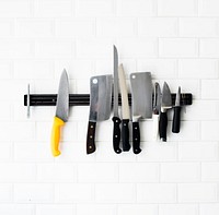 Set of knifes hanging on the white wall