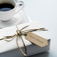 Closeup of gift box with empty label tag and coffee cup