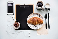 Aerial view of croissant coffee cup and paper clipboard