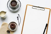 Aerial view of paper clip board and coffee cup