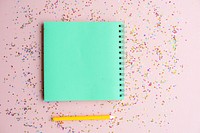 Blank notebook and pen with confetti