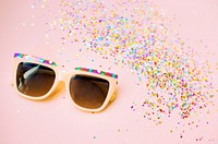 Sunglasses and confetti isolated on background