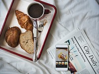 Aerial view of breakfast bread coffee in tray on bed