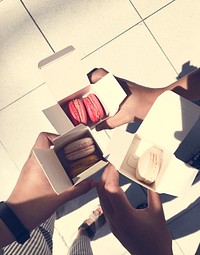 People Holding Macarons In Box