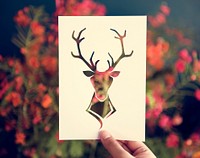 Hand Hold Deer with Antlers Paper Carving with Flower Background
