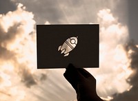 Hand Hold Space Rocket Paper Carving with Sky Background