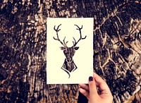Human hand holding wild life moose perforated paper craft in nat