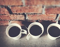 Closeup of coffee cups with brick wall background