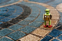 Retro tin robot toy standing on ground with pattern