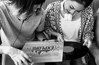 Closeup of diverse friends looking at music disc grayscale