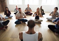 Diverse group of people in a yoga class doing a meditating pose