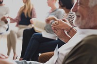 Diverse group of people holding hands in support group