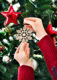 Putting a snowflake decoration on the Christmas tree