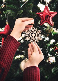 Putting a snowflake decoration on the Christmas tree