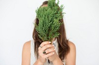 Girl holding plant in front of her face