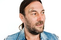 Mature guy wearing denim vest with band aid on forehead