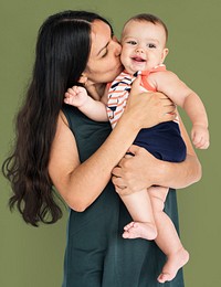 Mother kissing her child studio portrait