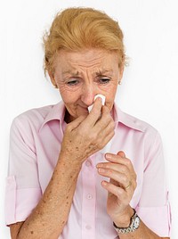 Senior woman crying or being sick with a runny nose