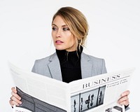 Studio portrait of a blonde woman reading the newspaper