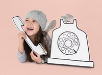 Little girl playing pretend with a paper phone