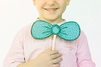 Little boy playing with papercraft bowtie and smiling
