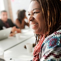 Close up of a woman with braids sitting at a table