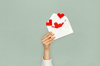 Hand holding envelope red paper hearts