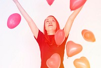 A caucasian woman is happy wtih a heart shape balloon.