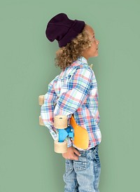 Boy holding a skateboard behind his back