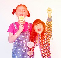 Children sisters happiness eating lillipop smilinng