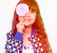 Little girl smiling and make lollipop covering eye